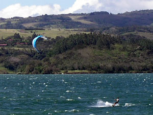 A kitesurfer leaps through the waves in front of the Rio Piedras hills. 